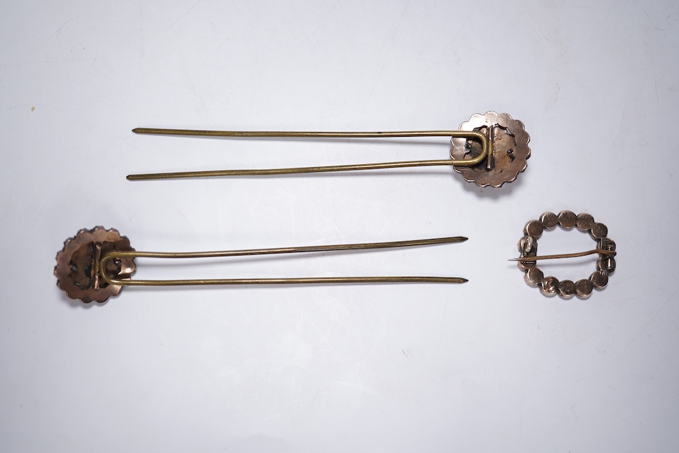 A Victorian yellow metal and garnet cluster set open work brooch, 27mm, together with two garnet cluster set hair ornaments. Condition - poor to fair